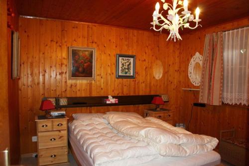 FlumsにあるChalet Schwalbeの木製の壁に大きなベッドが備わるベッドルーム1室