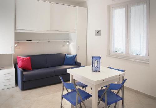 un soggiorno con divano, tavolo e sedie di Appartamento L'ONDA - 3 a Fezzano
