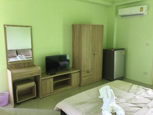 Habitación con cama, TV y espejo. en River Residence 2, en Ban Sung Yang
