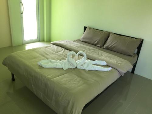 two swans towels sitting on top of a bed at River Residence 2 in Ban Sung Yang