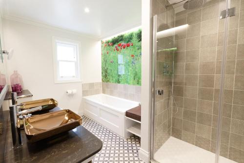 a bathroom with a tub and a sink and a shower at Gonville Hotel in Cambridge