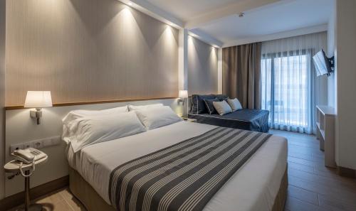 a hotel room with a bed and a chair at Rosamar Es Blau 4*s - Adults Only in Lloret de Mar