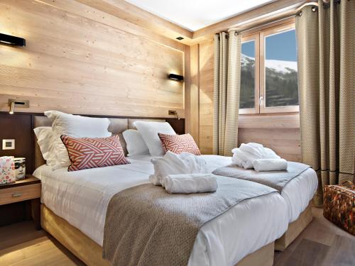 a bedroom with a large bed with pillows on it at MGM Hôtels & Résidences - Résidence Anitea in Valmorel