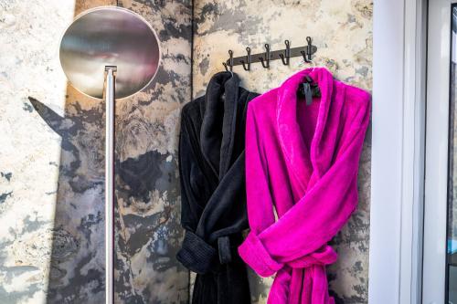 a pink towel hanging on a wall next to a mirror at Etoiles de Provence BIEN-ETRE in La Ciotat