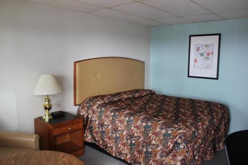 a hotel room with a bed and a lamp on a table at Midlands Lodge in Hastings