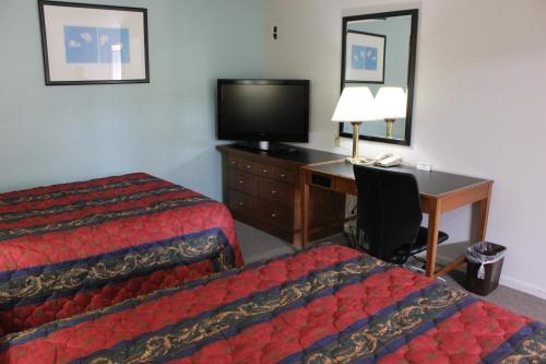 a hotel room with two beds and a desk with a computer at Midlands Lodge in Hastings