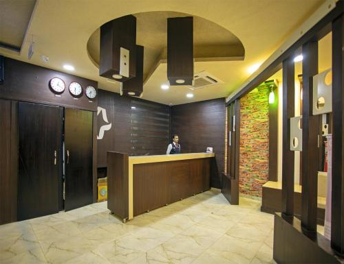 a man standing at a counter in a lobby at Star Emirates Inn Hotel Salalah in Salalah