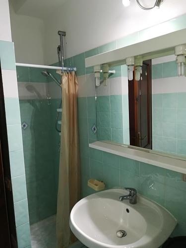 a bathroom with a sink and a mirror at Stella Marina Budoni in Budoni