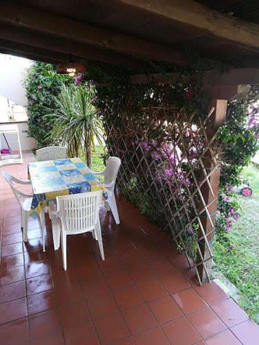 a table and chairs on a patio with flowers at Stella Marina Budoni in Budoni