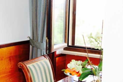 a table with a vase of flowers and a window at Balconata 2.0 Banqueting & Accommodations in Lucera