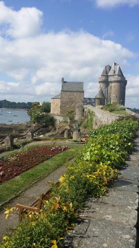 un castello con un campo di fiori davanti di Le clos de la cote d'Emeraude a Saint-Benoît-des-Ondes