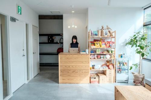 a woman sitting at a counter with a laptop at Blue Hour Kanazawa in Kanazawa