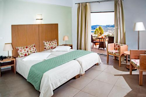 a bedroom with a large bed and a dining room at Kythea Resort in Agia Pelagia