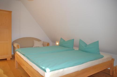 un letto con cuscini blu in una stanza di Ferienwohnung Passivhaus "Schöne Aussicht" a Georgensgmünd