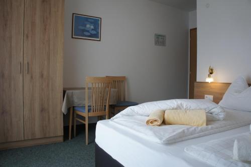 a hotel room with a bed with a towel on it at Pension Pernthaler in Silandro