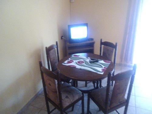 a dining room table with chairs and a television at Ośrodek Wczasowy "GRONOSTAJ" in Rajcza