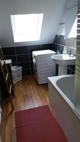 La salle de bains est pourvue d'un lavabo, d'une baignoire et d'une fenêtre. dans l'établissement Le Vivier appartement avec parking, à Boulogne-sur-Mer