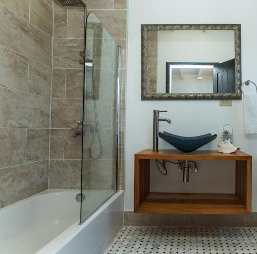a bathroom with a tub and a sink and a mirror at Turtles Nest Villa in Treasure Beach