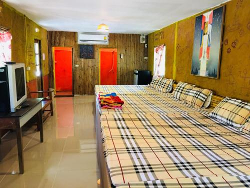 a bedroom with a bed and a tv and red doors at Numpu Baandin in Sam Roi Yot