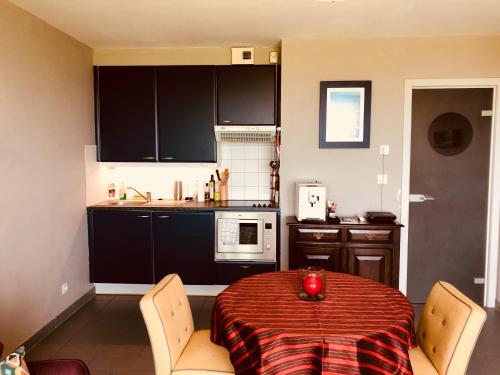 une cuisine avec une table ornée d'ornements rouges dans l'établissement Les Dunes Du Golf First Line Sea View App Block B 1-3, à Wimereux