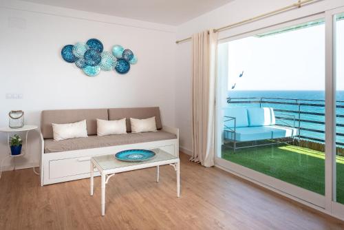 マルベーリャにあるApartamento Mediterraneo Viewのリビングルーム(ソファ付)が備わり、海の景色を望めます。
