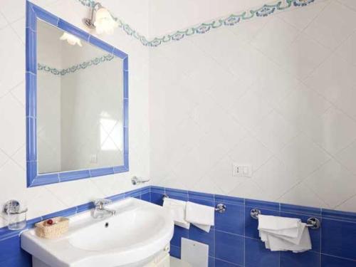 łazienka z białą umywalką i lustrem w obiekcie Hotel Residence Villa Igea Capri w mieście Capri