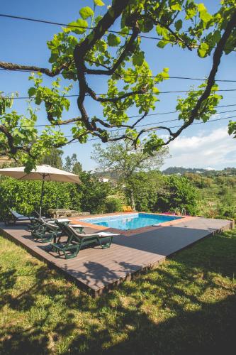 a swimming pool with two lounge chairs and an umbrella at Out of Town in Castelo de Paiva