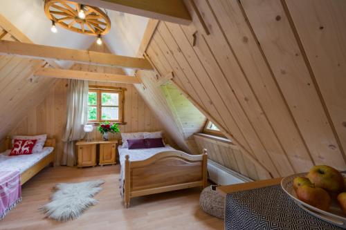 a attic room with a bed and a table at Domek Szałas pod Dębem in Ząb