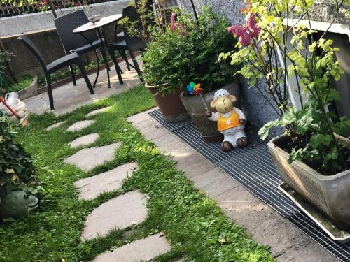 a teddy bear sitting on a blanket in a garden at Garni Villa Betty in Merano