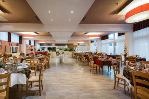 a dining room with tables and chairs and tablesearcher at Medjugorje Hotel & Spa in Međugorje