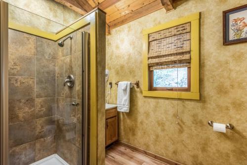 a bathroom with a shower and a walk in shower at Authentic log home with hot tub, fireplace, fire pit and billiards ! in Gatlinburg