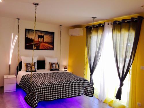 a bedroom with a black and white bed and a window at Etoiles de Provence BIEN-ETRE in La Ciotat