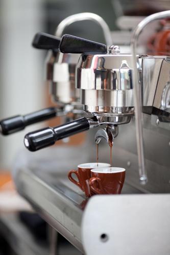 a coffee machine pouring coffee into a cup at Maca Villas & Spa Bali in Seminyak