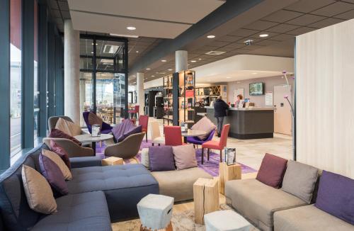 a store lobby with couches and tables and chairs at Campanile Le Mans Centre - Gare in Le Mans