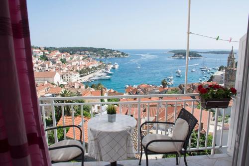 a balcony with a table and chairs and a view of the water at Apartments Boćin Rosso in Hvar