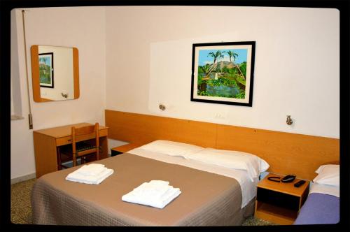 - une chambre d'hôtel avec un lit et un miroir dans l'établissement Hotel Belvedere, à Viareggio