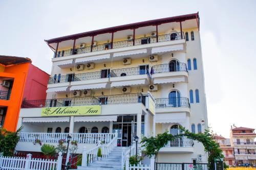 a white building with stairs in front of it at Adriani Inn in Paralia Katerinis