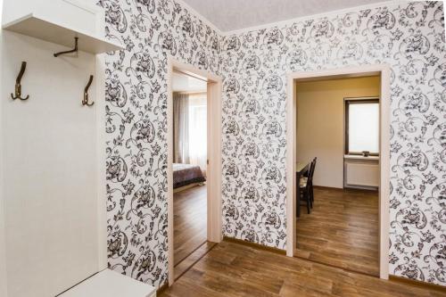 a hallway with a room with floral wallpaper at Apartment on Kharkovskaya 66 in Tyumen