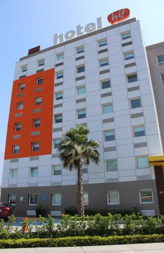 a hotel building with a palm tree in front of it at Hotel Hi! Santa Catarina in Monterrey