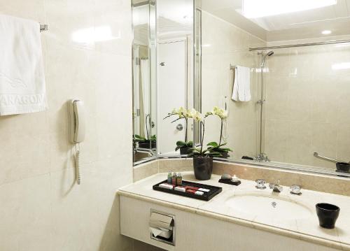 a white bathroom with a sink and a mirror at Hotel Paragon in Busan