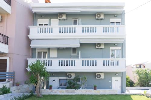a pink apartment building with a white balcony at Thegaia Studios in Rethymno Town