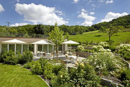 a garden with chairs and umbrellas at Landgasthof Jagstmühle in Heimhausen