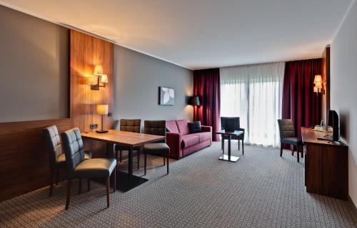バート・ランゲンザルツァにあるSante Royale Hotel- & Gesundheitsresort Bad Langensalzaのリビングルーム(テーブル、ソファ付)