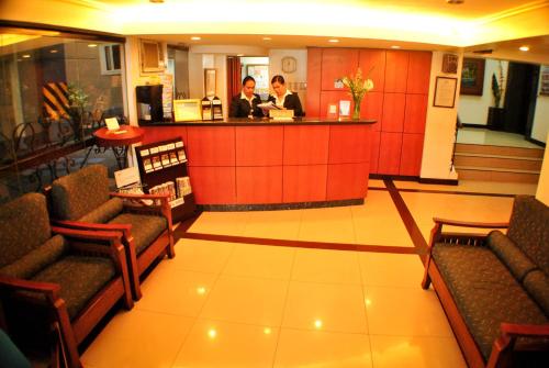 two people standing at a counter in a lobby at Fersal Hotel - Manila in Manila