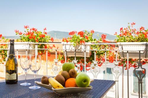 un piatto di frutta su un tavolo con una bottiglia di vino di Le Residenze del Centro a Olbia