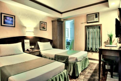 a hotel room with two beds and a television at Fersal Hotel - Manila in Manila
