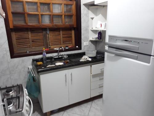 a kitchen with a sink and a refrigerator at Oberon in Curitiba