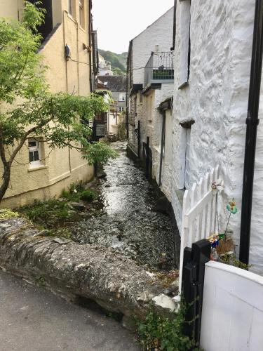 an alley between two buildings with a white fence at The Claremont Hotel-Adult Only in Polperro