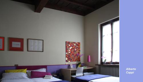 - une chambre avec 2 lits, un bureau et une fenêtre dans l'établissement B&B Casa dei Poeti, à Mantoue