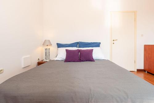 sypialnia z dużym łóżkiem z fioletowymi poduszkami w obiekcie Studio Luka w Rovinj